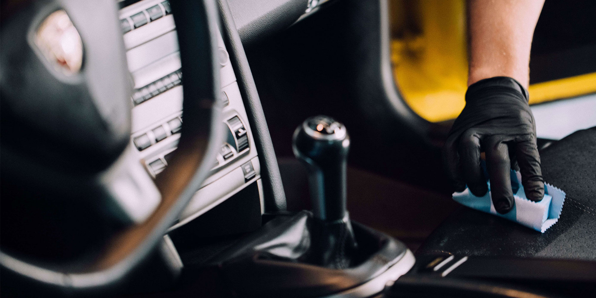 A RestorFX Technician protecting the leather console of a yellow sports car with ClearFX Interior product